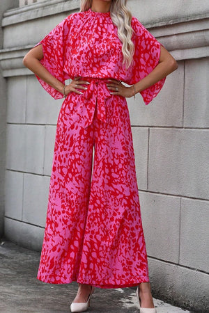 Crimson Splatter Tie-Waist Palazzo Jumpsuit in hot pink with wide legs and split sleeves.