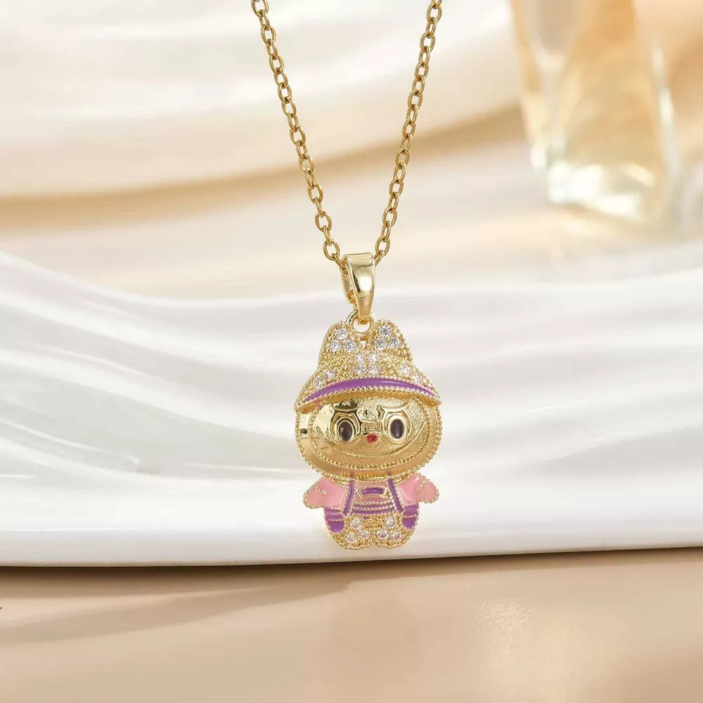 Gold-plated character pendant necklace with pink and purple enamel details and crystal accents.