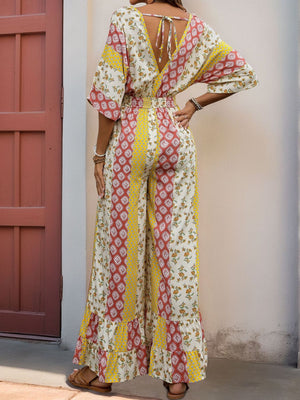 Bohemian print palazzo jumpsuit with V-neck and tie back, featuring wide legs and ruffle hem.