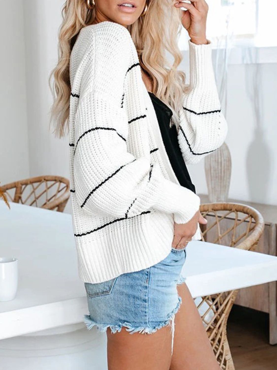 White open knit cardigan with horizontal black stripes, acrylic material, casual style.