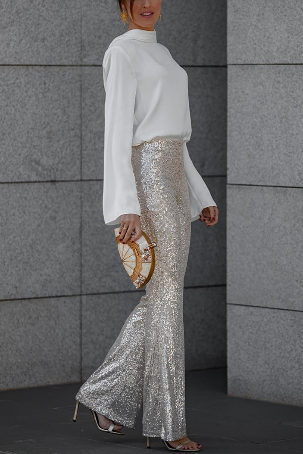 White silk blouse with draped back detail and bell sleeves worn by a model.