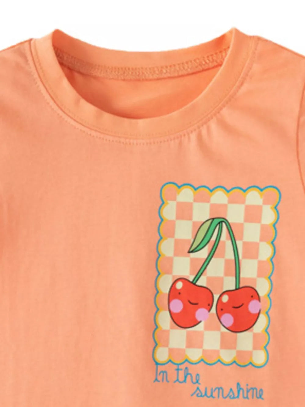 Toddler t-shirt in peach with a cheerful cherry graphic and "In the sunshine" text.