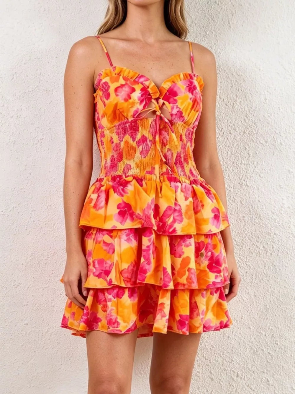 Floral cutout mini dress with tiered skirt and tie front in orange and pink.