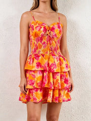Floral cutout mini dress with tiered skirt and tie front in orange and pink.
