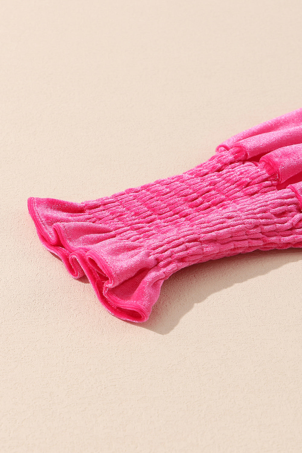 Hot pink velvet mini dress with smocked bodice detail and ruffled hem.