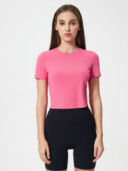 Fuchsia pink cropped performance crew neck top with short sleeves.