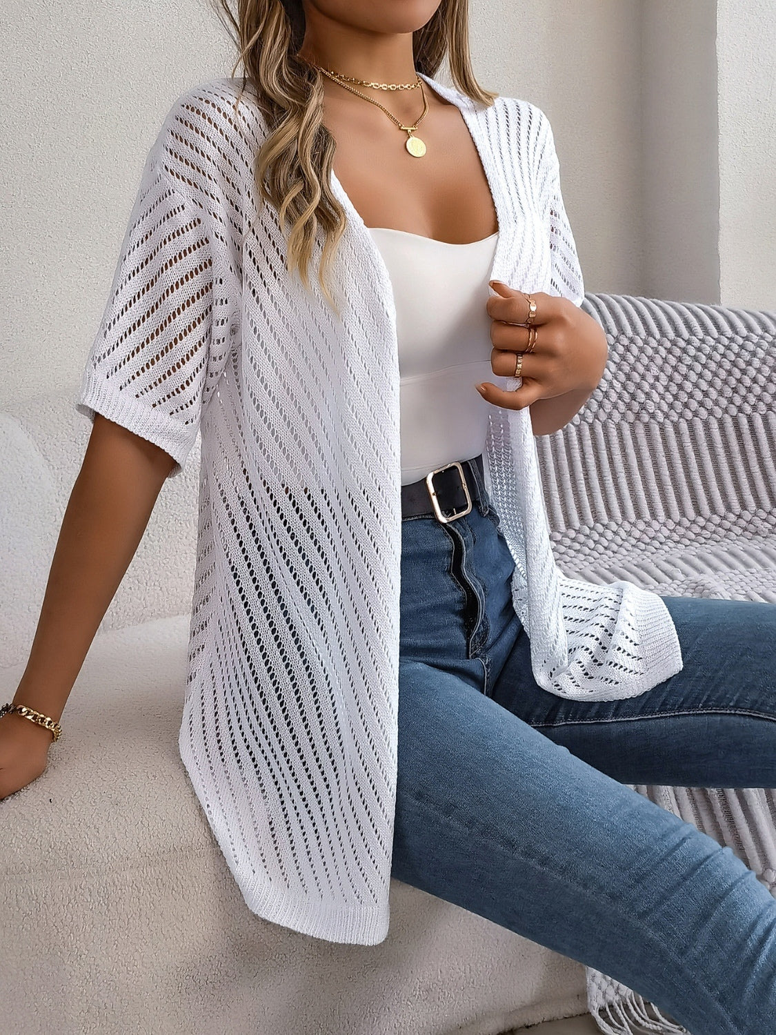 White open-knit slouchy cardigan with short sleeves and diagonal stitch detail.