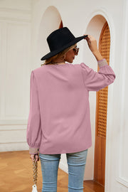 Blush pink blouson top with embroidered trim on sleeves and a ribbed texture.