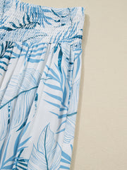 Tropical leaf print wide leg pants in white and blue with smocked waist and pockets.