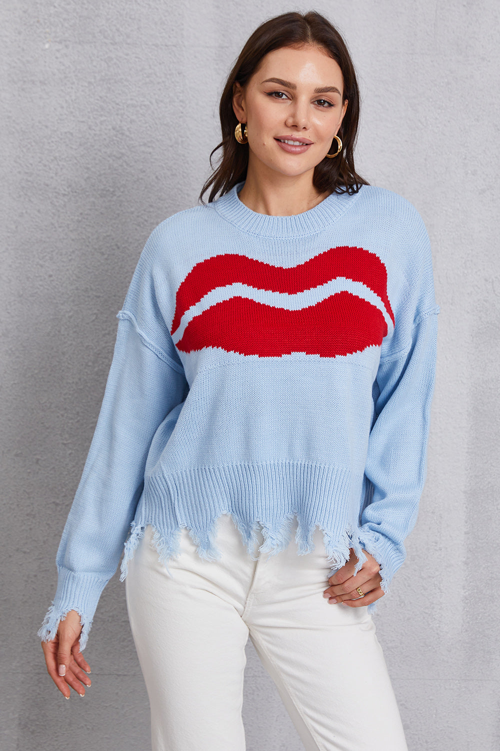 Light blue acrylic sweater with red kiss graphic and distressed hem.