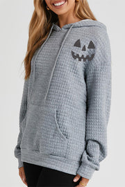 Charcoal waffle knit hoodie with jack-o-lantern graphic and front pocket.