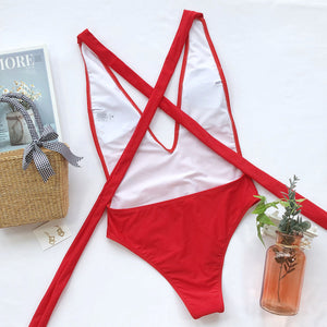 Red wrap-around halterneck plunge swimsuit with crisscross back straps.