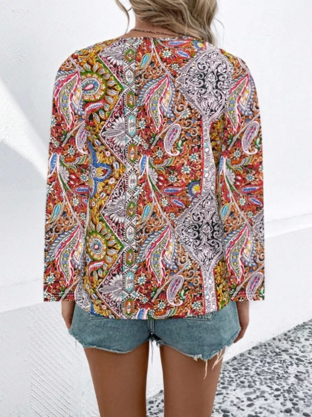 Bohemian paisley v-neck shirt in multicolor with long sleeves, styled with denim shorts.