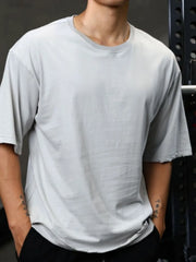Distressed oversized gray t-shirt with raw edges and a crew neck.