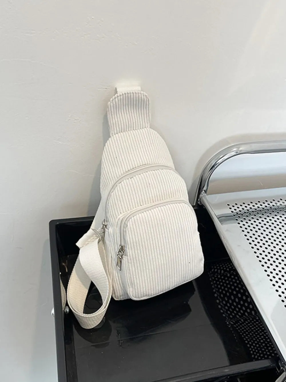 White corduroy sling bag with zip pockets and adjustable strap
