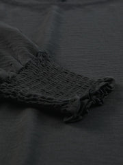 Black textured sleeve blouse with elastic smocked cuffs and ruffled hem detail.