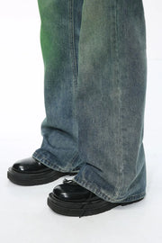 Ombre flare denim trousers in medium wash cotton, with a relaxed fit and slight green tint.