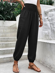 Black relaxed-fit cargo pants with smocked waist and cuffed ankles.