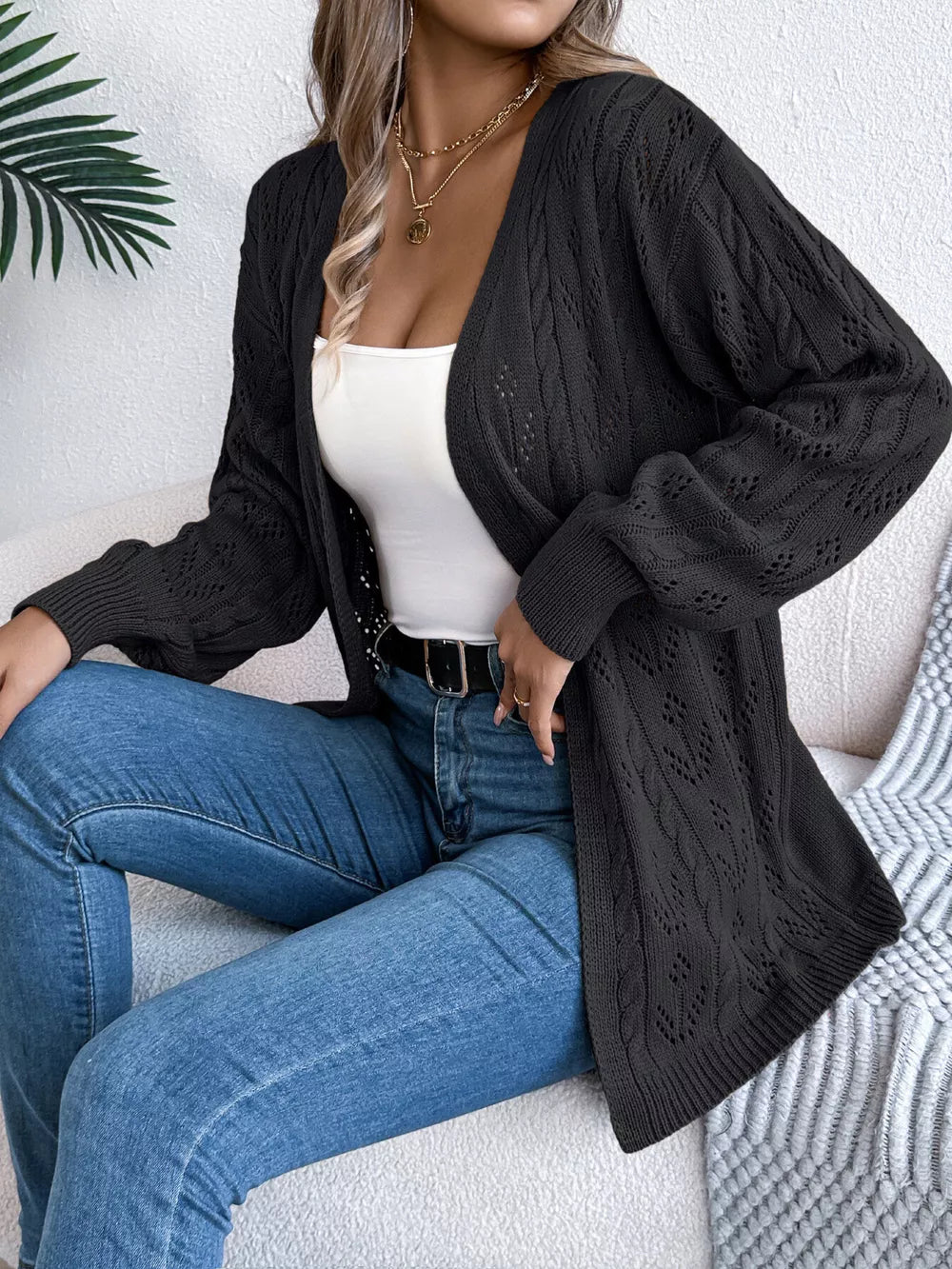 Black openwork cable knit long sleeve cardigan with open front.