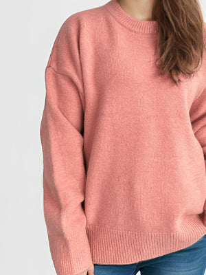 Oversized crewneck knit pullover sweater in Burnt Coral acrylic with ribbed cuffs and hem.