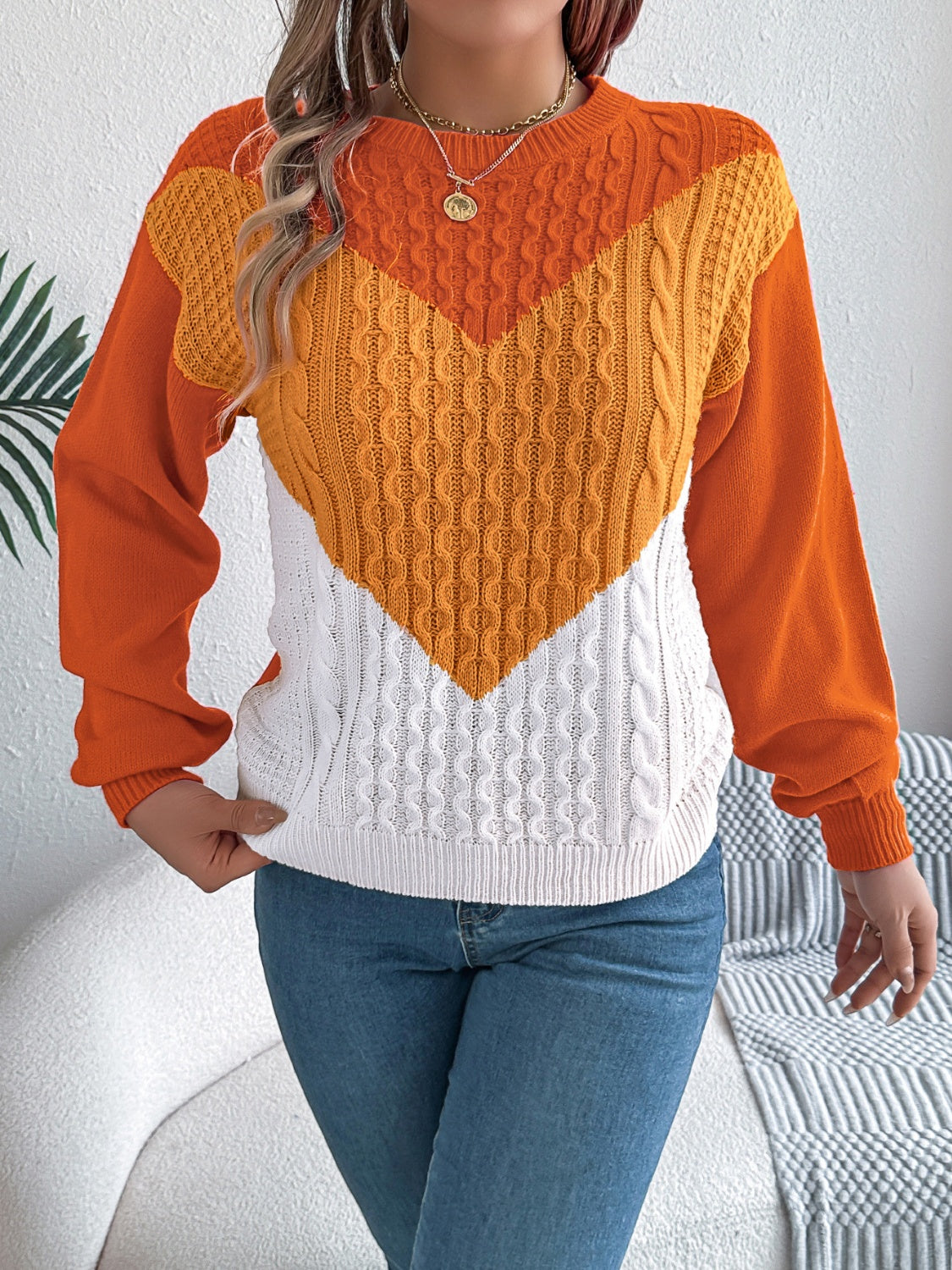 Chevron cable knit sweater with contrast orange, yellow, and white colorblock design.