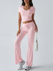 Blush pink button-front crop top and flared lounge pants with drawstring waist.