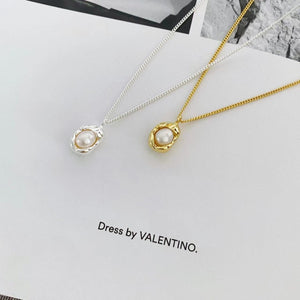 Sterling pearl pendant necklace in silver and gold, featuring a delicate pearl set in an organic metal frame.