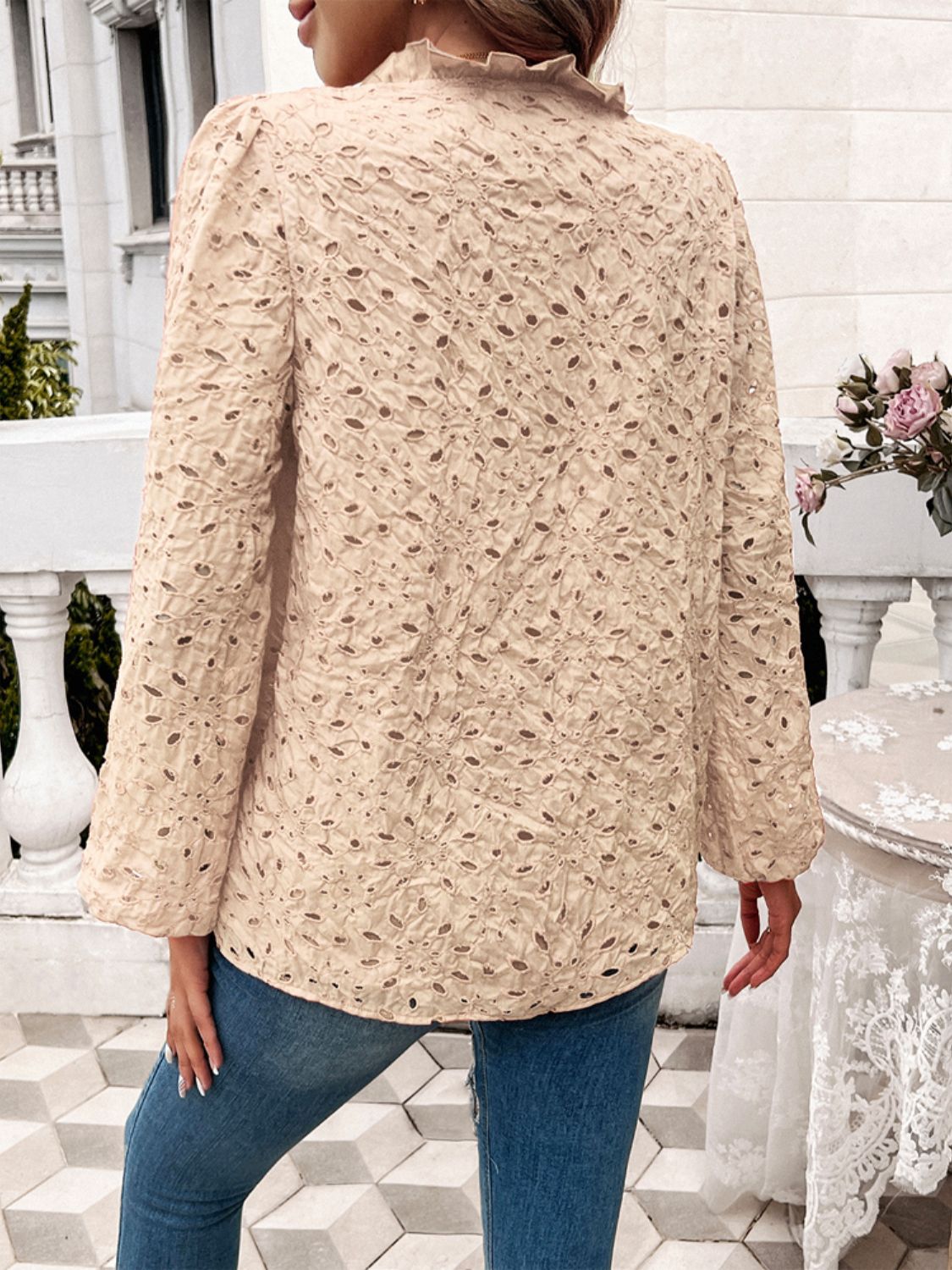Tan eyelet embroidered blouse with ruffle collar and puff sleeves.
