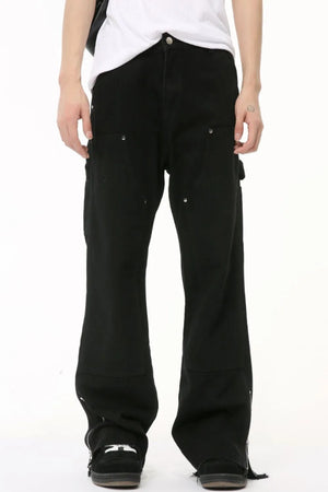 Black bootcut denim pants with zip hem detail and utility pockets.