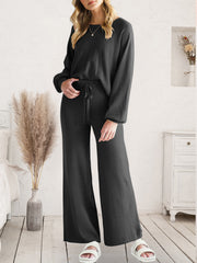 Black acrylic loungewear set with wide-leg pants and crewneck top, featuring a drawstring waist.