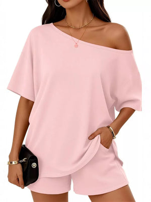 Pink asymmetrical one-shoulder top and shorts set with pockets.