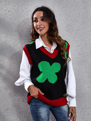Black acrylic knit vest with green clover intarsia pattern and red trim