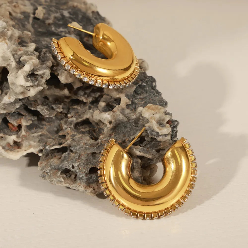 Gold cubic zirconia embellished crescent hoop earrings with a polished finish.