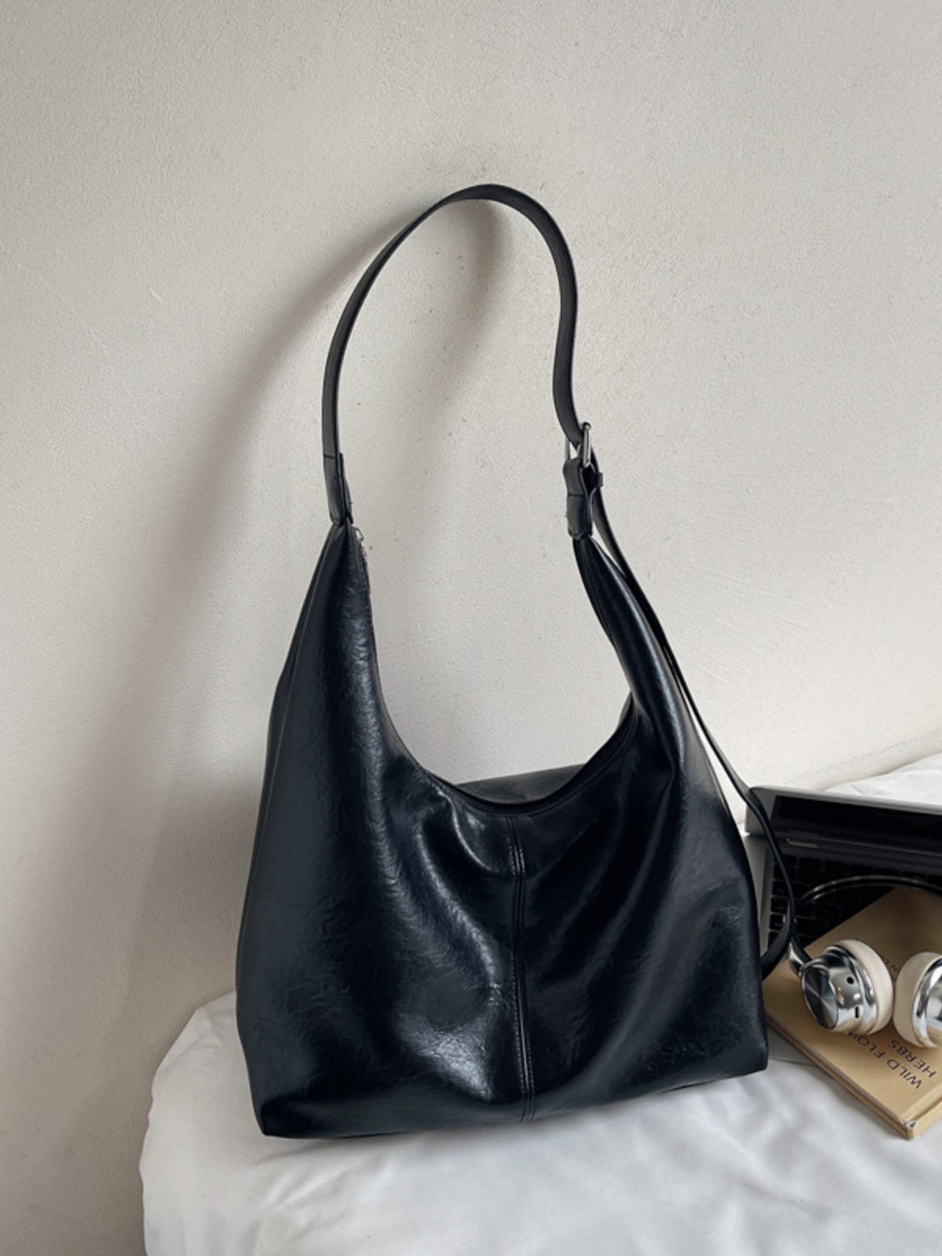 Black leather shoulder bag with adjustable strap and slouchy silhouette