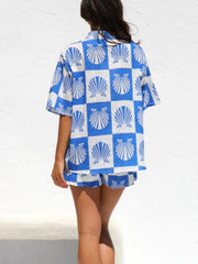 Blue and white checkered resort set with shell print, button-up shirt and shorts.
