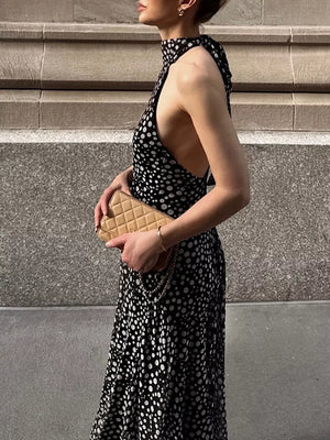 Black and white polka dot halter maxi dress with a high neckline and open sides.