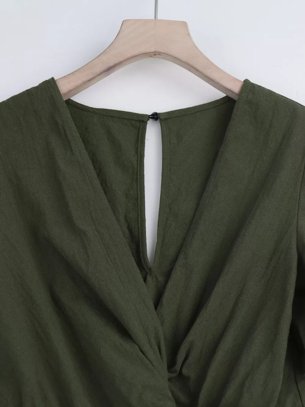 Olive green cotton romper with V-neck and back keyhole detail.