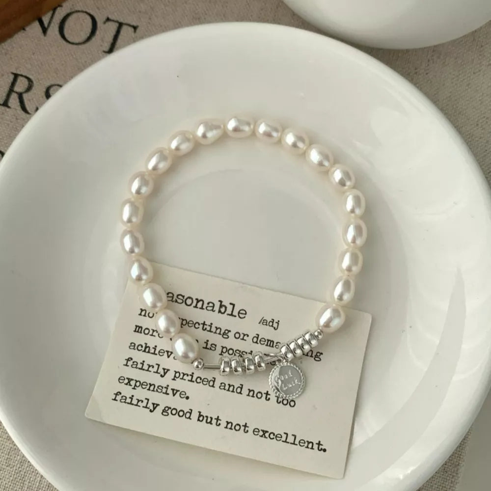 Delicate freshwater pearl and silver bracelet with charm
