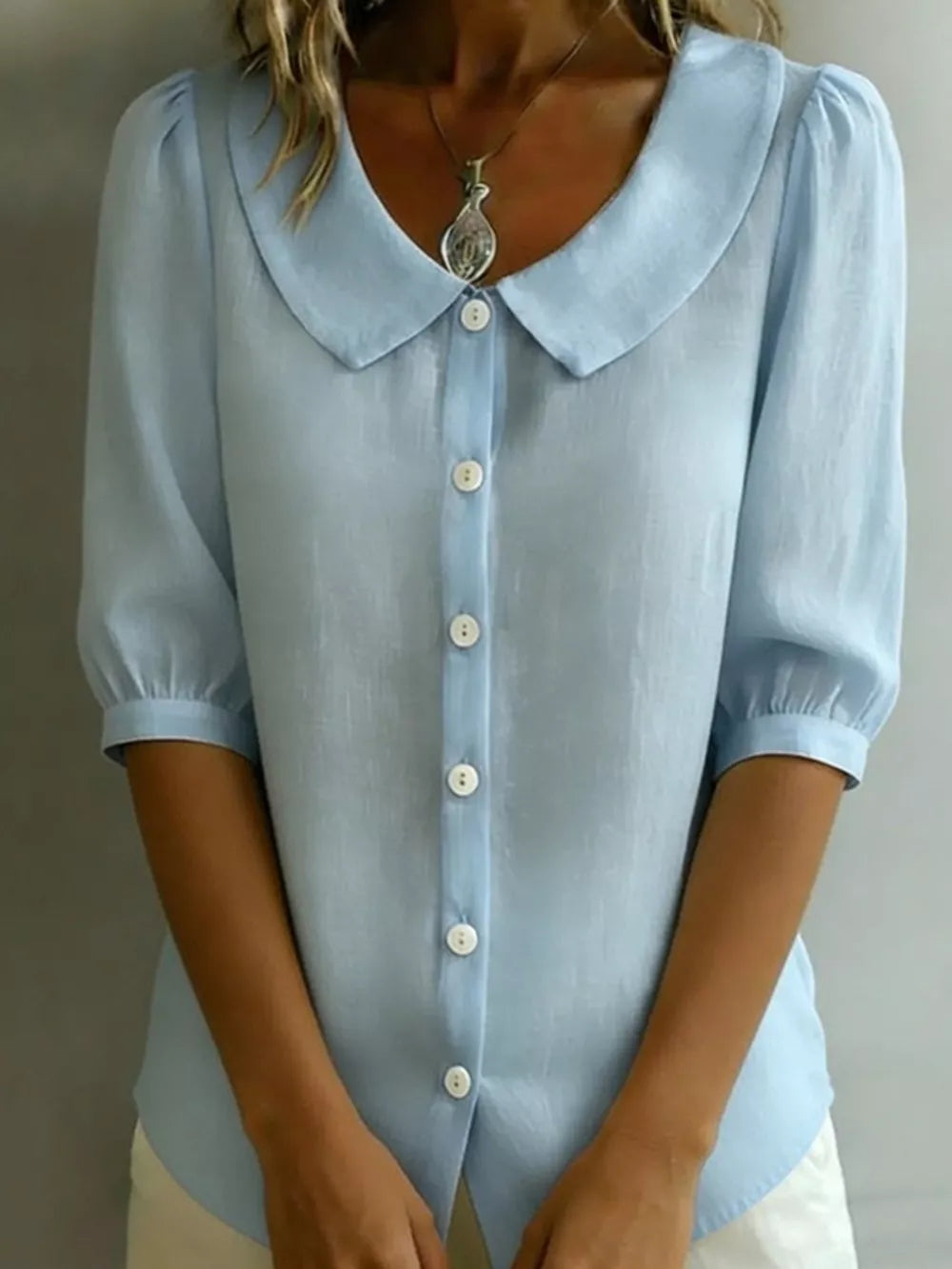 Light blue puff sleeve shirt with Peter Pan collar and button-down front.