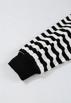 Black and white striped blouse with ribbed cuffs and wavy stripe pattern.