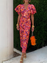 Vibrant abstract print midi dress with V-neck, puff sleeves, and ruched waist.