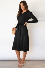 Black cable knit midi dress with self-tie belt and long sleeves.