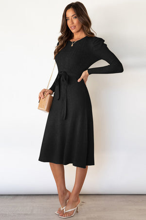 Black cable knit midi dress with self-tie belt and long sleeves.