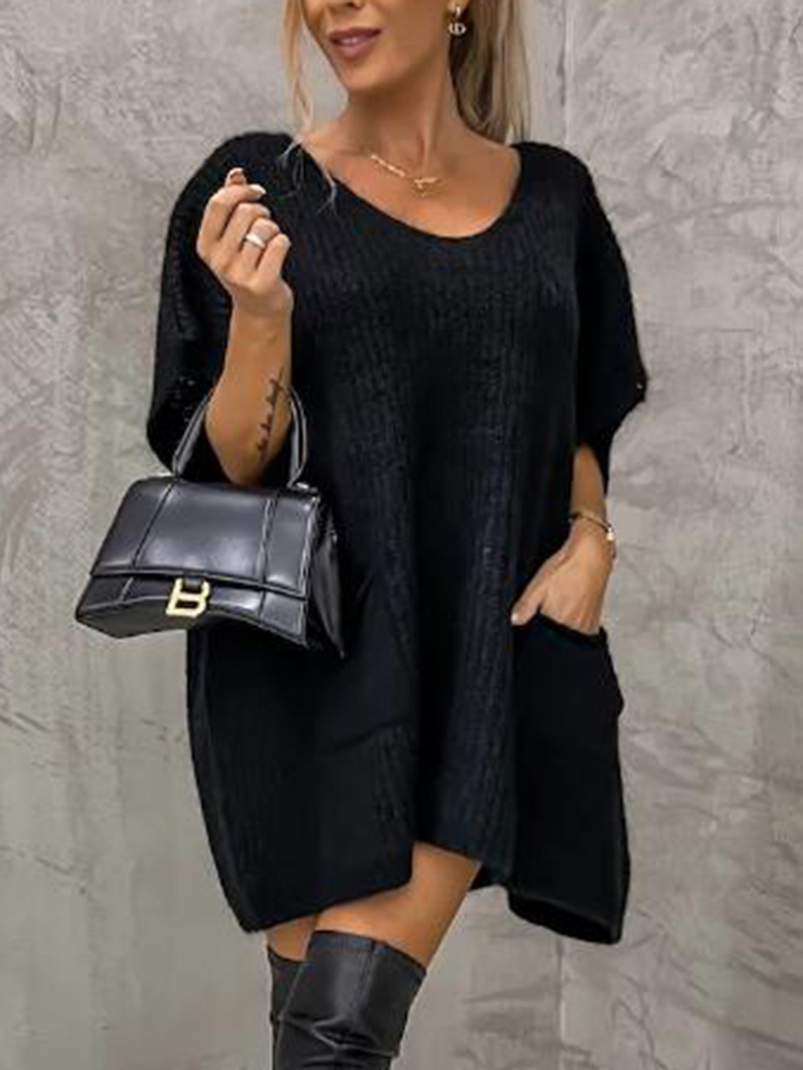 Black knit tunic with V-neck, short sleeves, and front pockets.