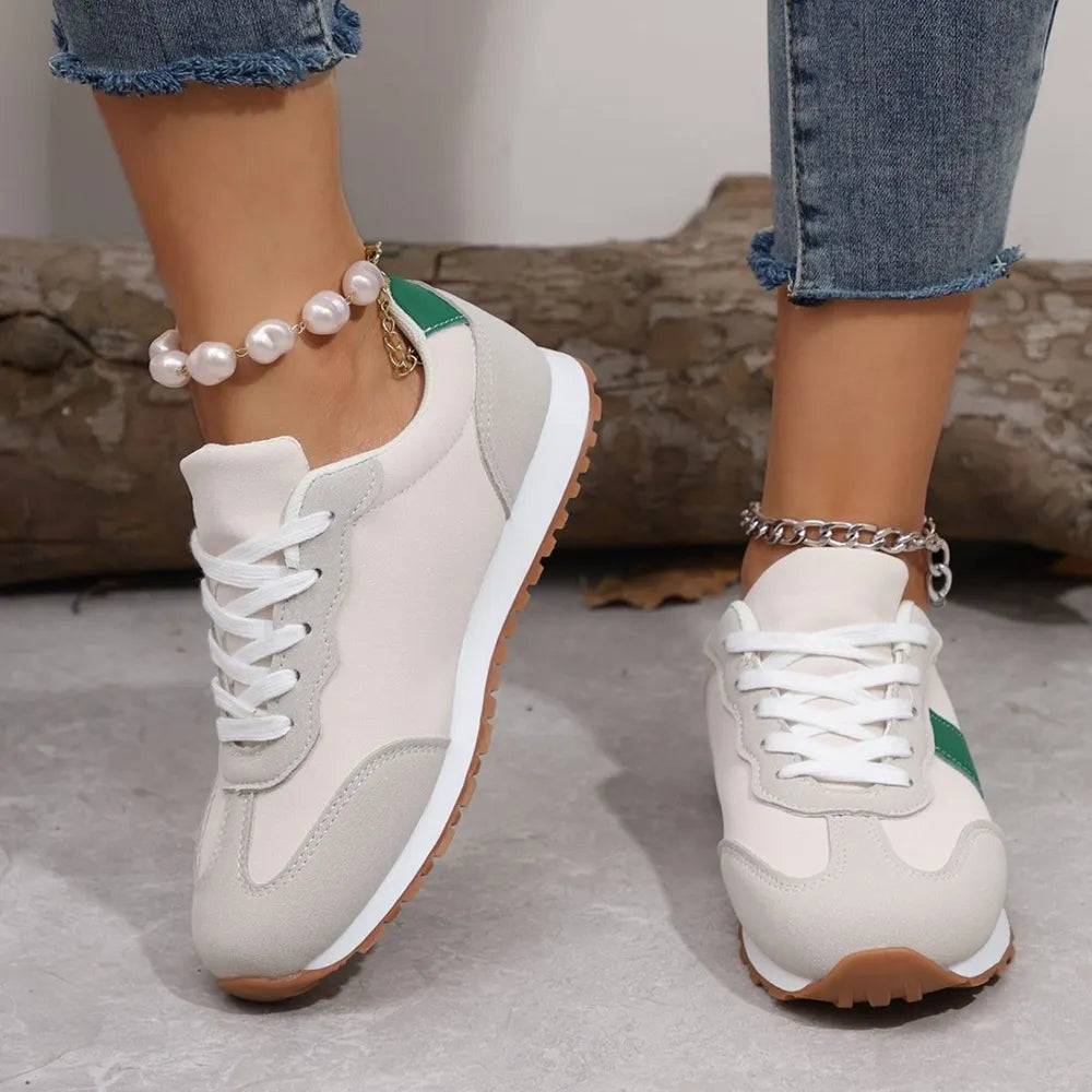 Beige suede and canvas sneakers with green accents and white laces.