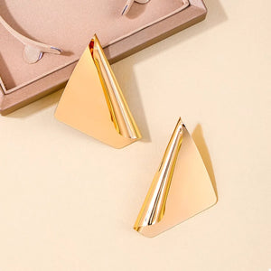 Gold sculptural triangle earrings with a polished finish.