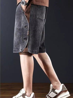 Men's dark gray wide leg denim shorts with button detail and corduroy inset.