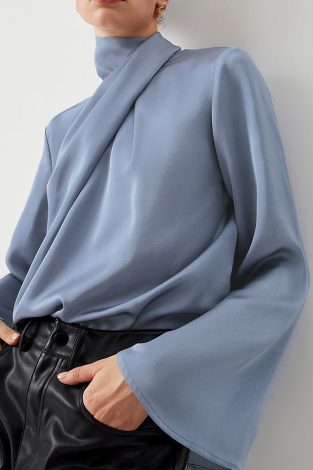 Dusty blue blouse with draped neckline and bell sleeves.