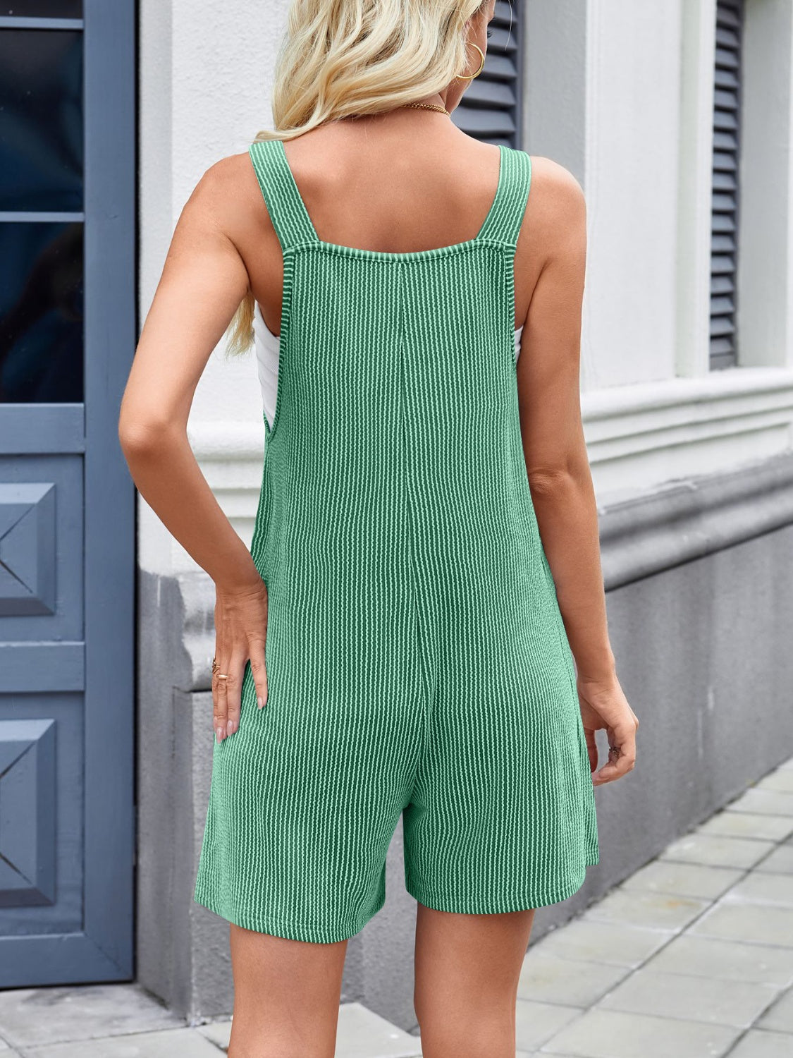 Green ribbed romper overalls with white pinstripes and wide straps.