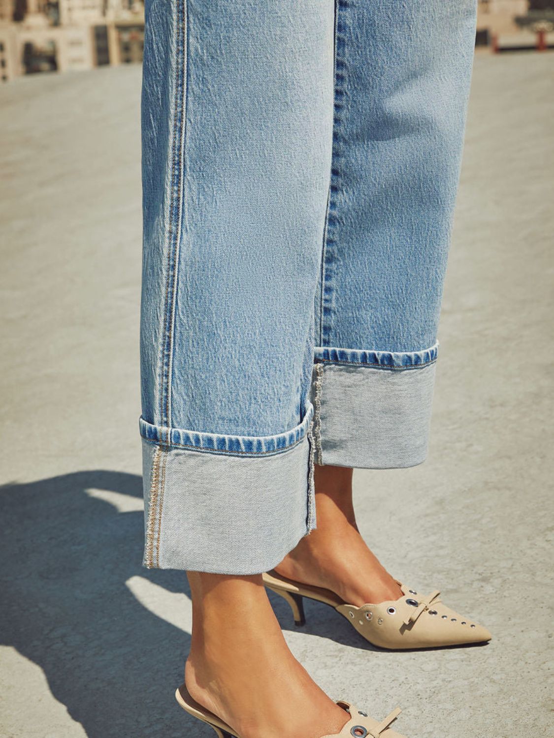 Light wash denim jeans with wide legs and large cuffs.